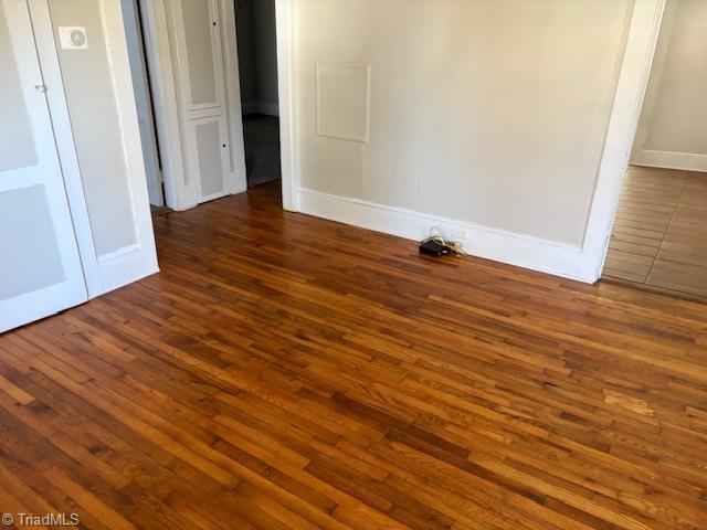 spare room with dark hardwood / wood-style floors