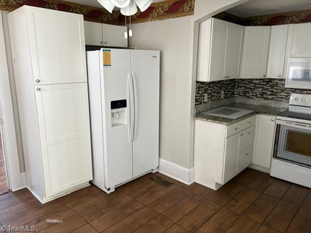 kitchen with white cabinetry, white appliances, dark hardwood / wood-style flooring, and decorative backsplash