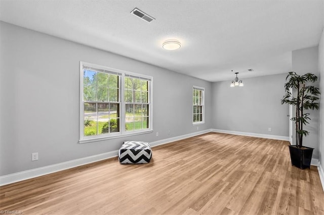 4 Manard Ct, Greensboro, NC 27407 - unfurnished room featuring a chandelier, light wood-style floors, and baseboards