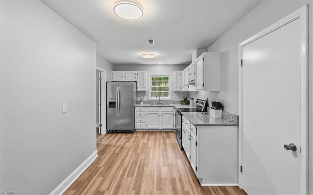 4 Manard Ct, Greensboro, NC 27407 - kitchen with stainless steel appliances, a sink, white cabinetry, light wood-style floors, and light stone countertops