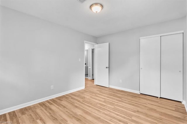 4 Manard Ct, Greensboro, NC 27407 - unfurnished bedroom featuring light wood-style flooring, baseboards, and a closet