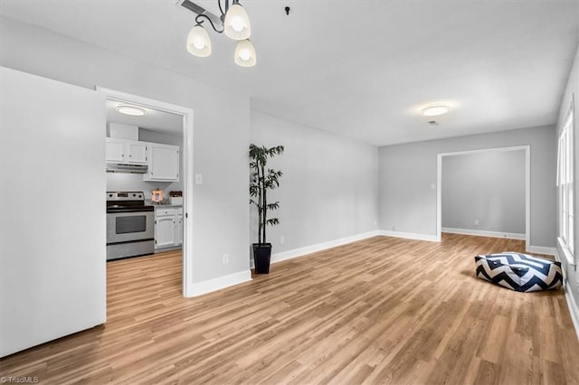 4 Manard Ct, Greensboro, NC 27407 - unfurnished living room with light wood-type flooring, baseboards, and a chandelier