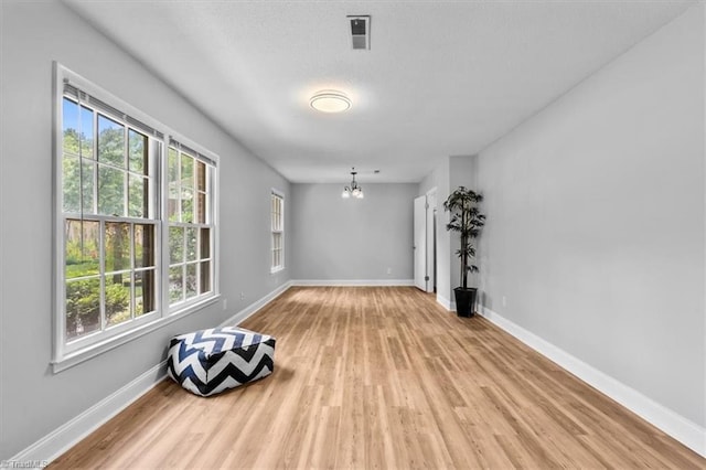 4 Manard Ct, Greensboro, NC 27407 - spare room with a chandelier, light wood finished floors, and baseboards