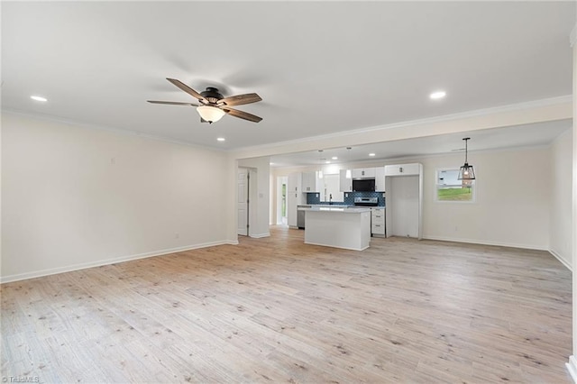 unfurnished living room featuring recessed lighting, ornamental molding, light wood finished floors, baseboards, and a ceiling fan