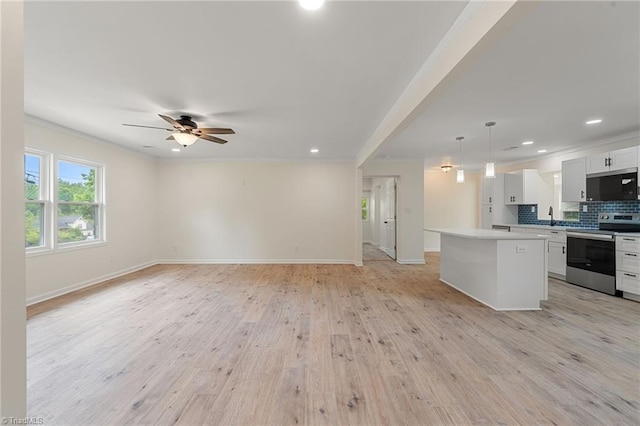 kitchen with stainless steel appliances, ceiling fan, a center island, crown molding, and open floor plan