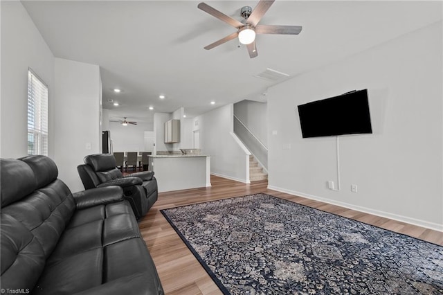 living area with ceiling fan, stairs, recessed lighting, baseboards, and light wood-type flooring