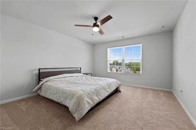 carpeted bedroom with baseboards and a ceiling fan