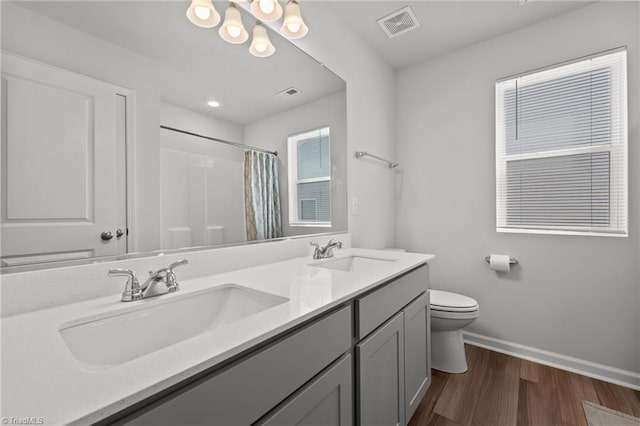 full bath with a sink, baseboards, toilet, and visible vents