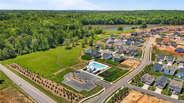 bird's eye view featuring a water view, a view of trees, and a residential view