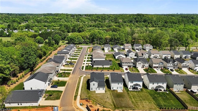 birds eye view of property featuring a residential view and a wooded view