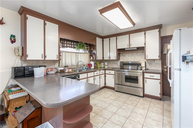 kitchen with white fridge, white cabinetry, stainless steel electric range, sink, and decorative backsplash