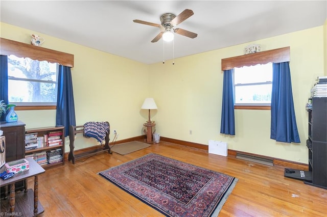 sitting room with hardwood / wood-style floors and ceiling fan