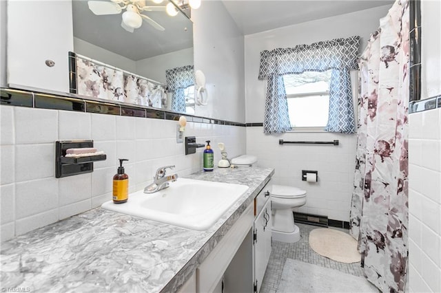 bathroom featuring vanity, tasteful backsplash, tile walls, toilet, and ceiling fan