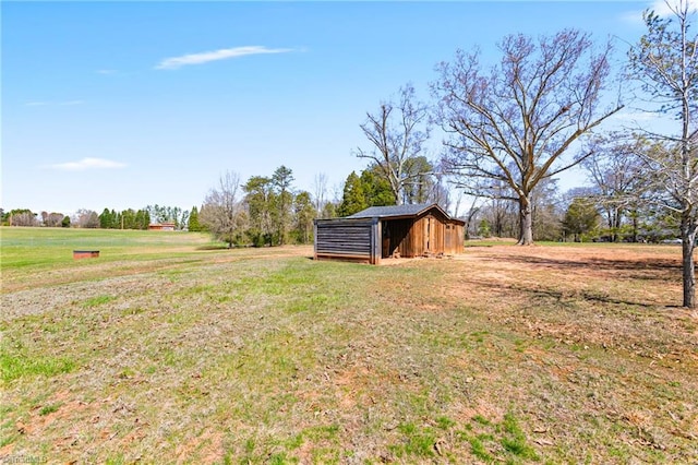 view of yard with an outbuilding and a rural view