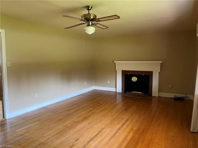 unfurnished living room featuring wood-type flooring, a fireplace, and ceiling fan