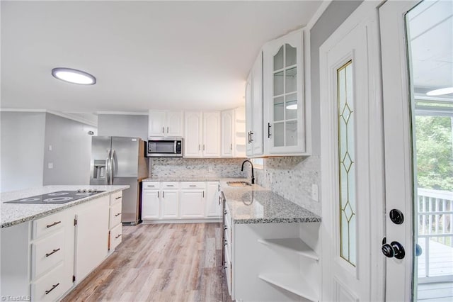 kitchen with white cabinets, stainless steel appliances, sink, and light stone countertops