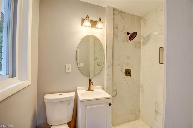 bathroom featuring tiled shower, vanity, and toilet