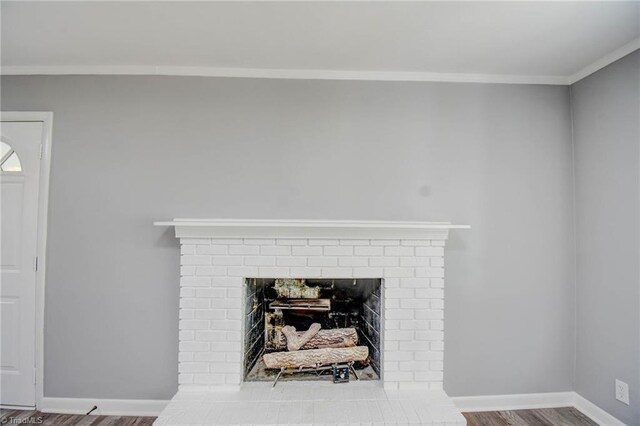 details with a brick fireplace, hardwood / wood-style flooring, and ornamental molding