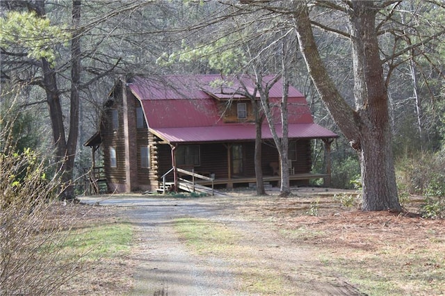 view of outdoor structure featuring a porch and driveway