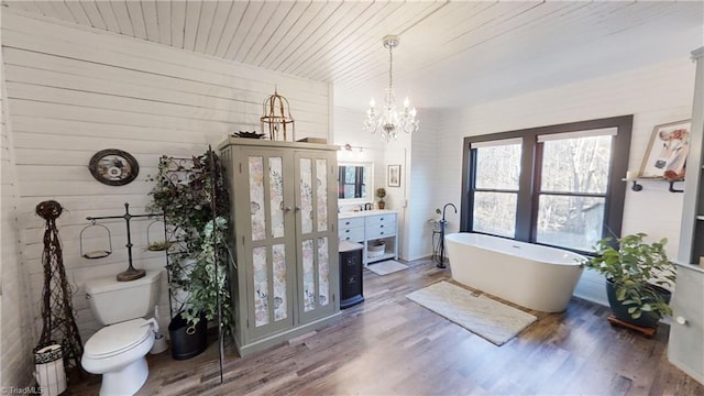 bathroom with wooden ceiling, toilet, wood-type flooring, a washtub, and a notable chandelier