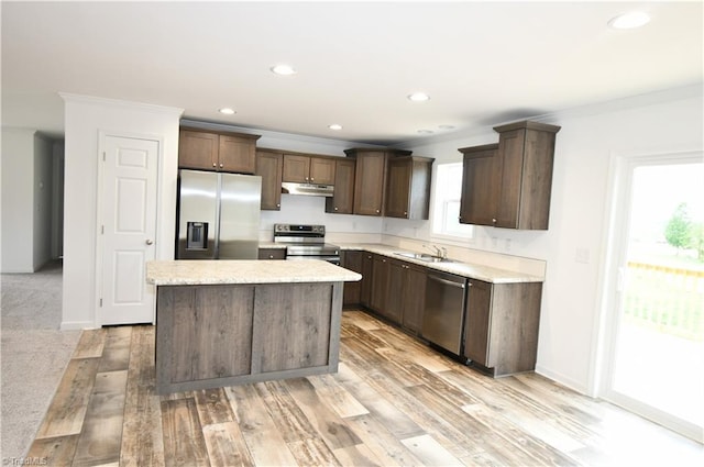 572 Kirby Bowman Rd, Siloam, NC 27047 - kitchen featuring stainless steel appliances, under cabinet range hood, dark brown cabinets, ornamental molding, and a center island