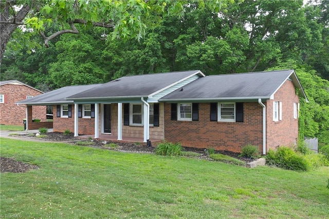 ranch-style home featuring a porch, brick siding, and a front yard