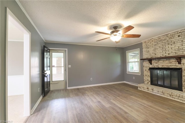 unfurnished living room featuring a textured ceiling, wood finished floors, a ceiling fan, and ornamental molding