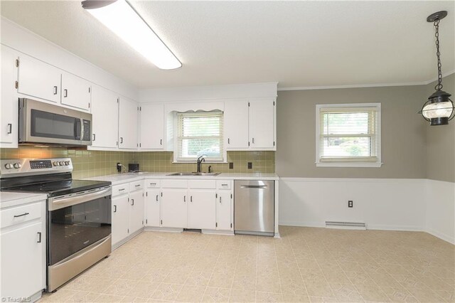 kitchen with a sink, stainless steel appliances, backsplash, light countertops, and white cabinets