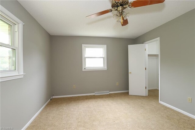 unfurnished bedroom with visible vents, baseboards, a walk in closet, and carpet floors