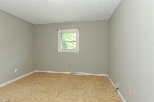 carpeted empty room with baseboards, visible vents, and a textured ceiling