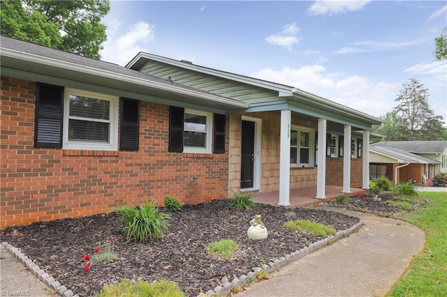 single story home with a porch and brick siding