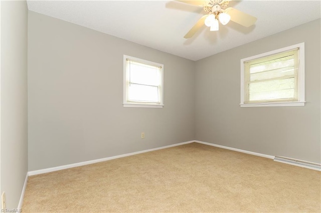 carpeted empty room featuring ceiling fan, baseboards, and visible vents