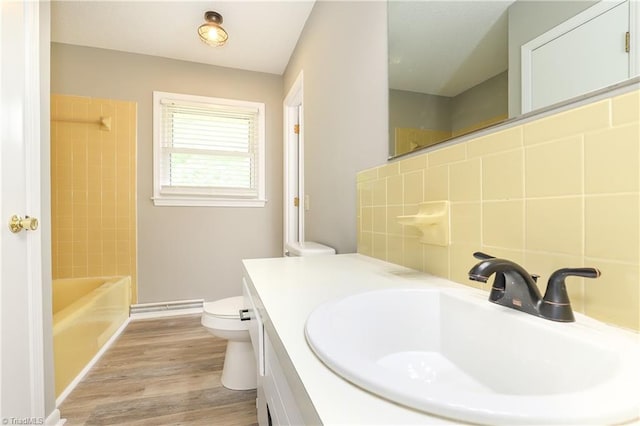 bathroom featuring toilet, backsplash, vanity, and wood finished floors