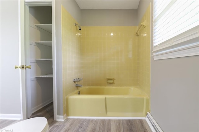 bathroom with toilet, bathtub / shower combination, and wood finished floors