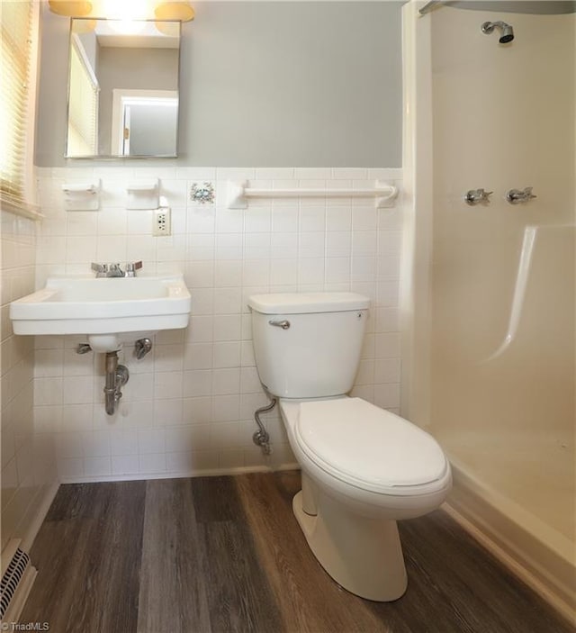 full bath with a walk in shower, wainscoting, toilet, and wood finished floors