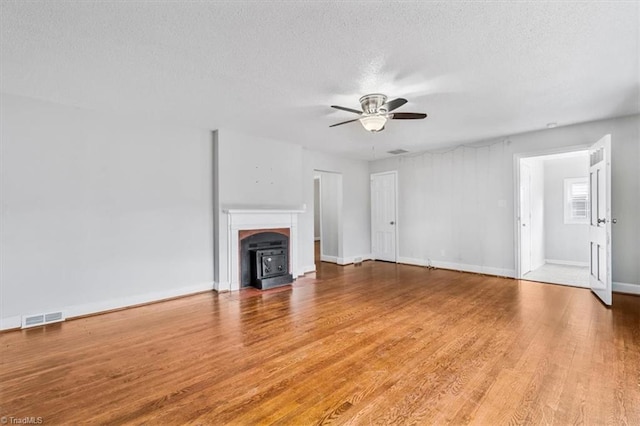 unfurnished living room featuring ceiling fan, wood-type flooring, and a textured ceiling