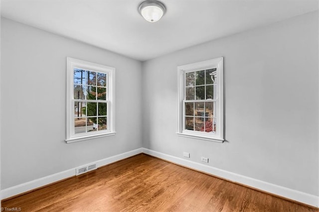 unfurnished room with hardwood / wood-style flooring