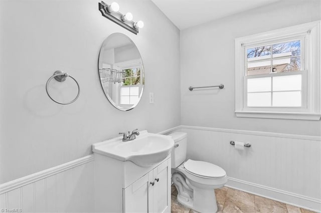 bathroom with vanity, toilet, and a wealth of natural light