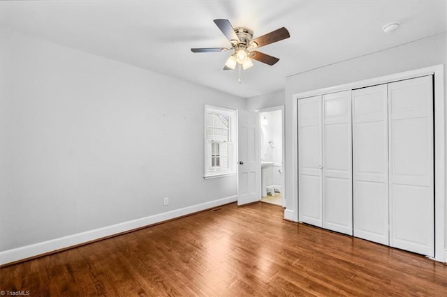 unfurnished bedroom featuring hardwood / wood-style floors, ensuite bath, a closet, and ceiling fan