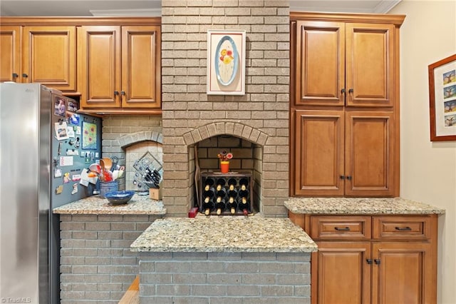 3805 Tangle Oak Dr, Clemmons, NC 27012 - kitchen with freestanding refrigerator, light stone countertops, crown molding, and brown cabinetry