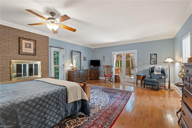 3805 Tangle Oak Dr, Clemmons, NC 27012 - bedroom with multiple windows, hardwood / wood-style flooring, french doors, a brick fireplace, and ornamental molding