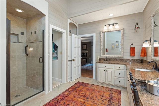 3805 Tangle Oak Dr, Clemmons, NC 27012 - full bathroom with double vanity, a stall shower, tile patterned flooring, wooden walls, and recessed lighting