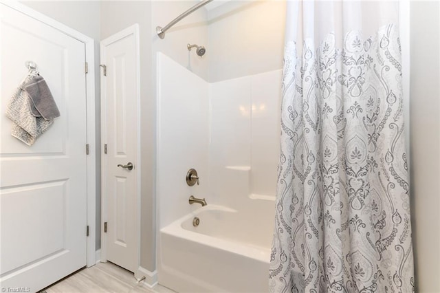 full bathroom featuring baseboards and shower / bathtub combination with curtain