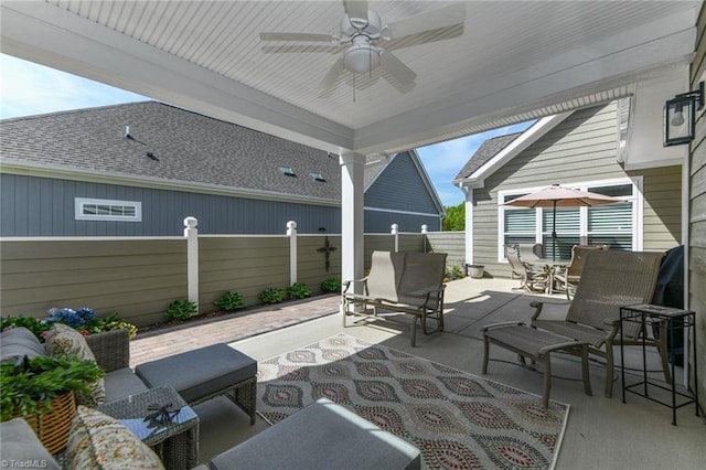 view of patio with fence, an outdoor hangout area, ceiling fan, and outdoor dining space
