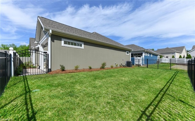 rear view of property featuring central air condition unit, a gate, a yard, and fence private yard
