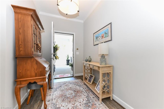 foyer featuring baseboards, ornamental molding, and wood finished floors