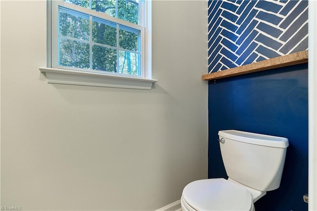 bathroom featuring baseboards and toilet