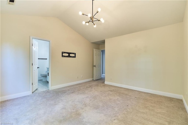 spare room with baseboards, lofted ceiling, a notable chandelier, and light carpet