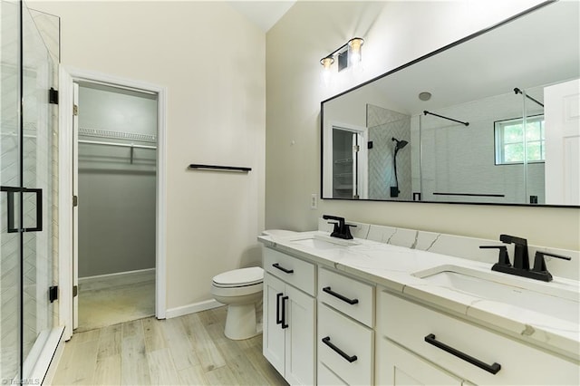 bathroom with a sink, a stall shower, and toilet