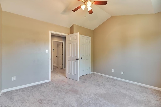 unfurnished bedroom with baseboards, ceiling fan, vaulted ceiling, and carpet flooring